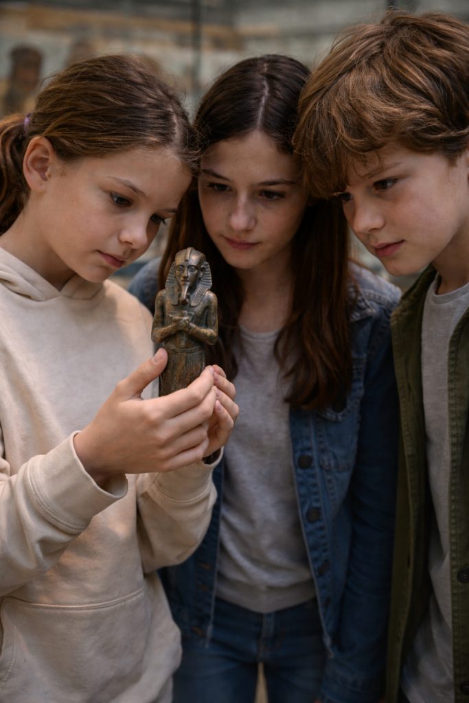 Kinder untersuchen ein Replikat einer ägyptischen Statuette